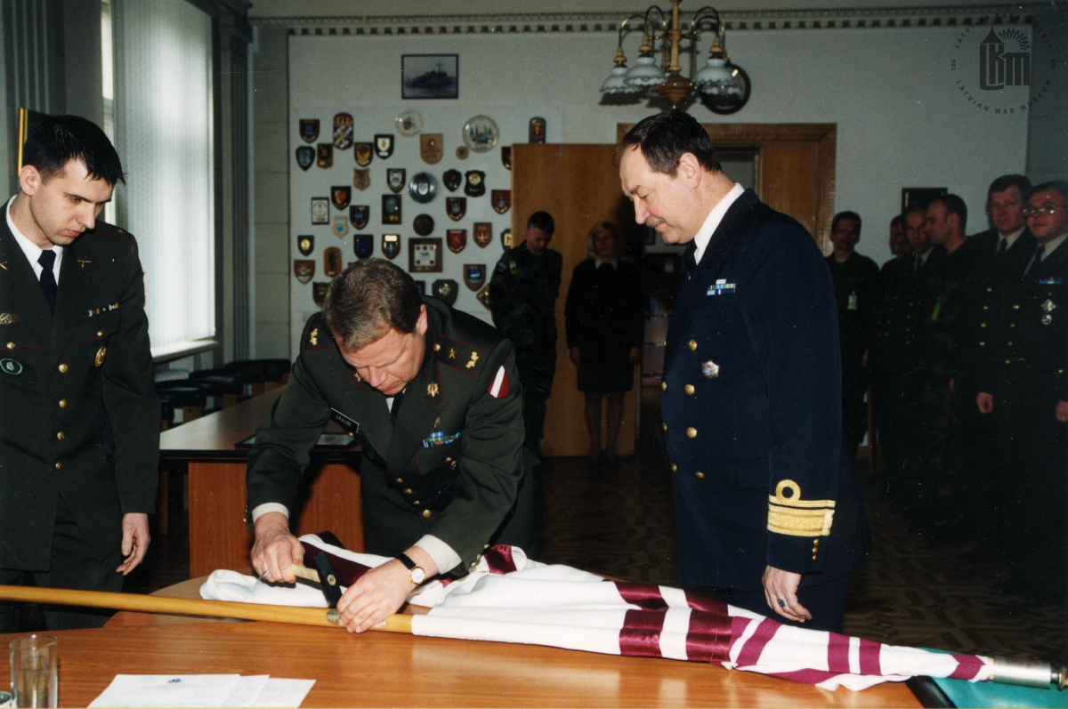 NBS komandieru maiņas ceremonija. NBS komandieris brigādes ģenerālis R. Graube iedzen NBS komandiera karoga kātā Karoga naglu. 2003. gada 30. janvāris. Fotogrāfs G. Binde. LKM krājums